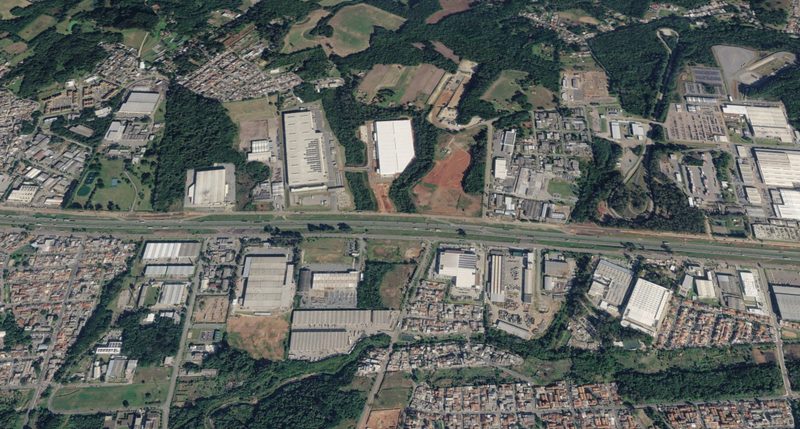 Vista aérea de área industrial e logística na Cidade Industrial de Curitiba, com galpões ao longo da rodovia